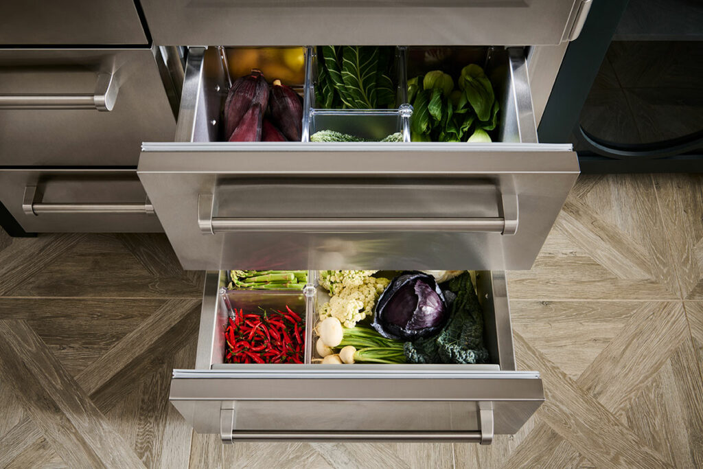 SubZero refrigerator drawers, open with fresh fruits and vegetables